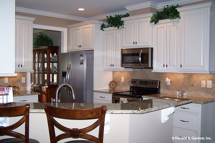 The kitchen includes a raised eating bar paired with wooden counter chairs.