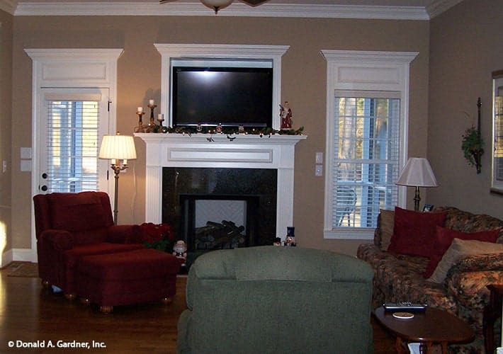 The living room offers multi-colored seats, a fireplace, and a wall-mounted TV.