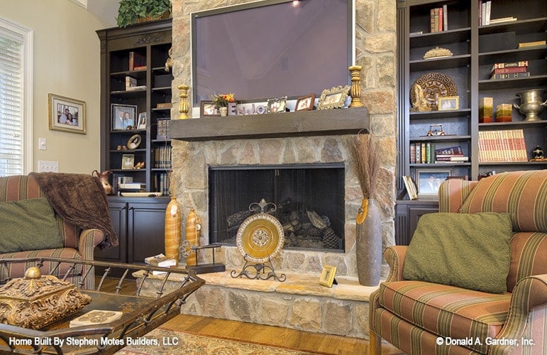 A closer look at the stone fireplace adorned with decorative vases, a ceramic plate, and small photo frames.