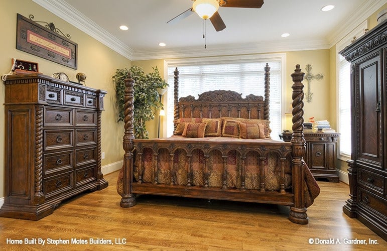 The primary bedroom features a four-poster bed and wooden cabinets inlaid with intricate detailing.