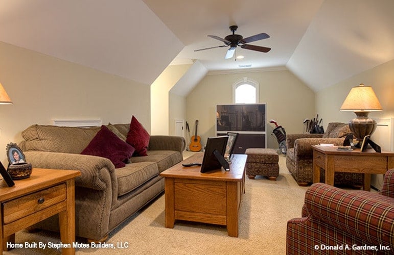 Bonus room with carpet flooring, vaulted ceiling, and fabric seats paired with wooden tables.