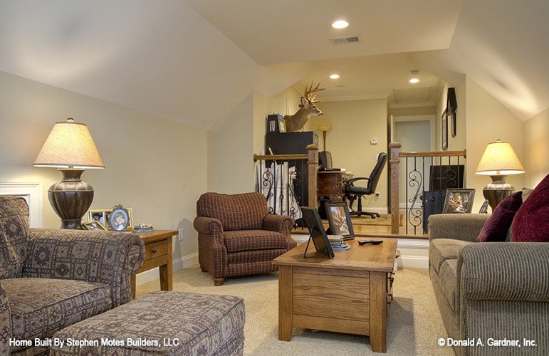 The bonus room includes an office space defined by ornate railings.