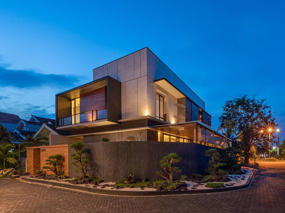 This is a nighttime view of the house exterior showcasing the warm yellow lights of the exterior and landscaping that pair with the interior lights.