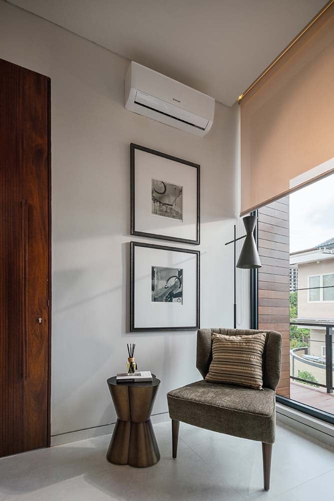 This is another reading nook and lounge area by the door next to the window paired with a small side table and a couple of wall artworks.