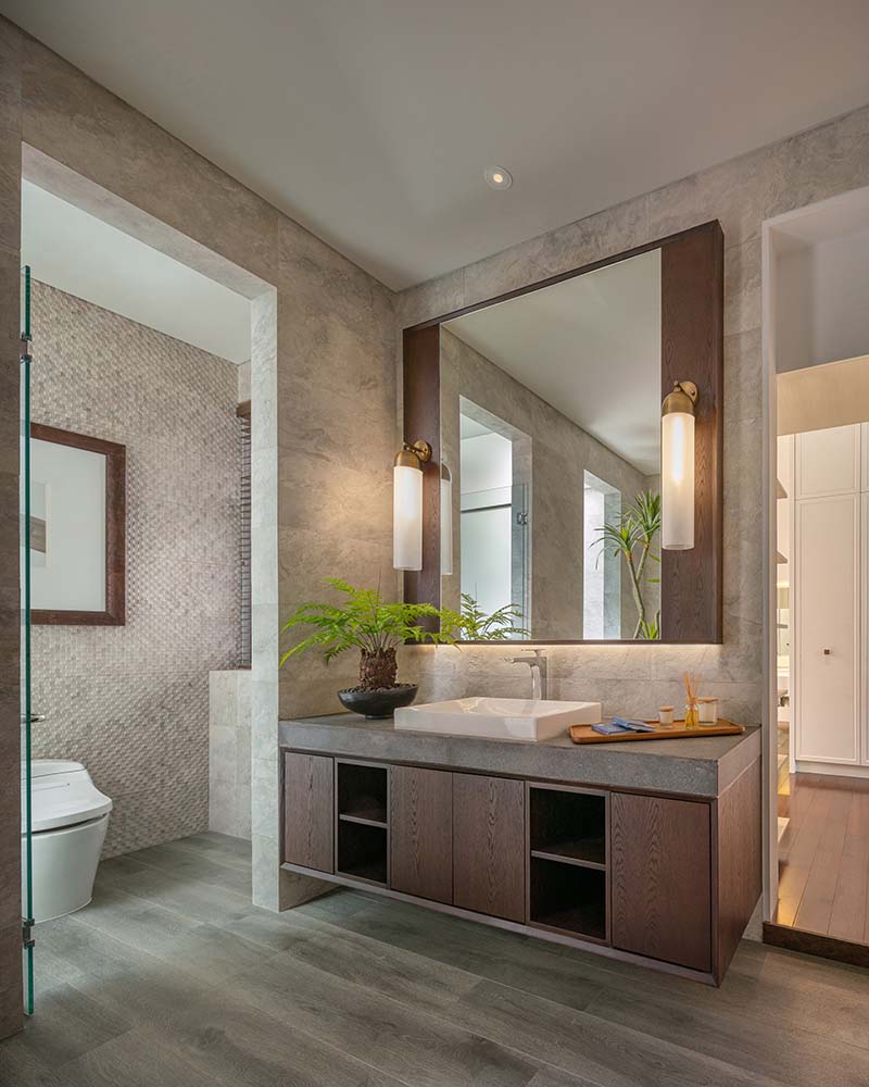The bathroom has a large vanity with a large mirror above flanked by sconces.