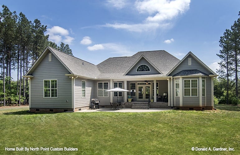 Rear exterior view with a covered porch and an open patio filled with an outdoor seating and a barbecue grill.