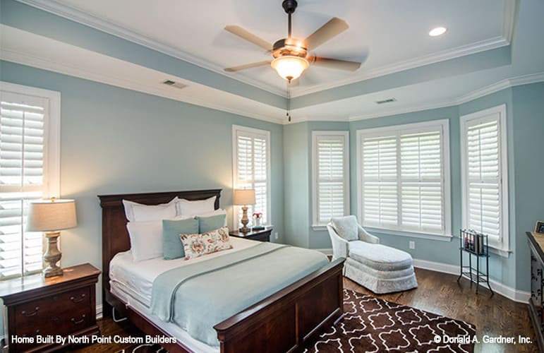 The primary bedroom features a tray ceiling and a bay window with a chaise lounge.