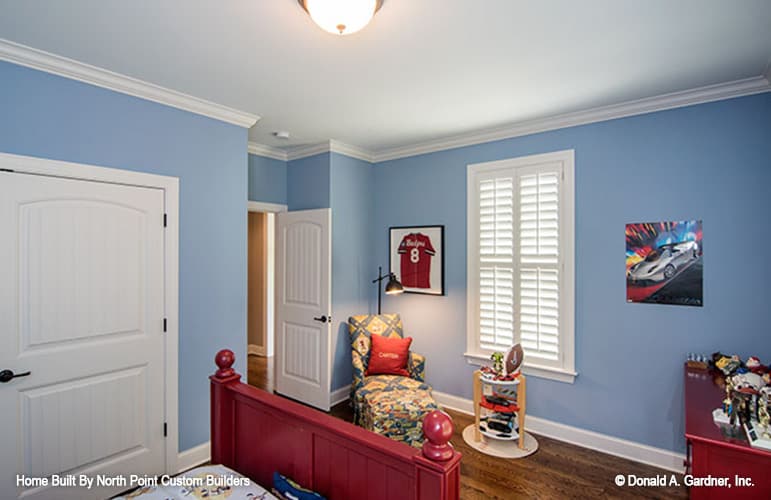 The bedroom includes a patterned chaise lounge and a wooden desk.