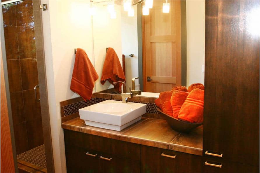 Bathroom with a walk-in shower and vessel sink vanity paired with a frameless mirror.