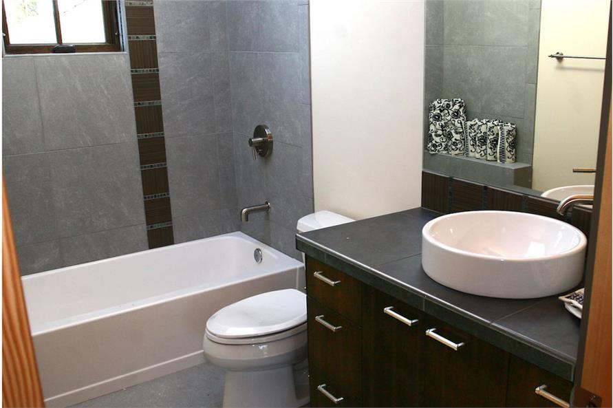 This bathroom is equipped with a sink vanity, a toilet, and a tub and shower combo.