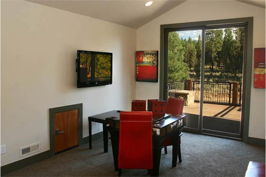 Bonus room with a wall-mounted TV, carpet flooring, and sliding glass doors that open to the rear deck.