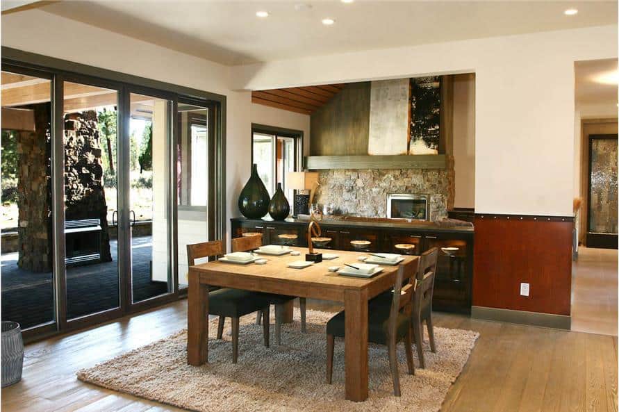 Dining room with buffet bar and a wooden dining set sitting on a plush area rug.