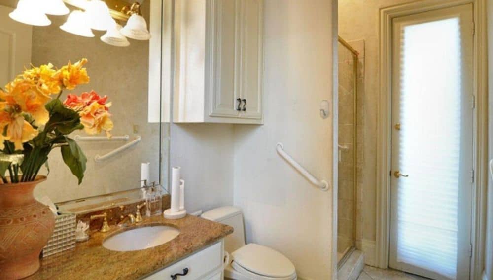 This bathroom is equipped with a sink vanity, a toilet, and a walk-in shower.