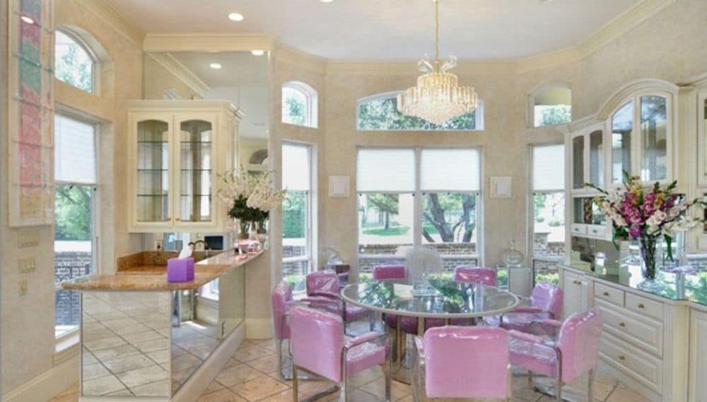 Breakfast nook with a bay window, a built-in bar, and a round dining set topped with a crystal chandelier.