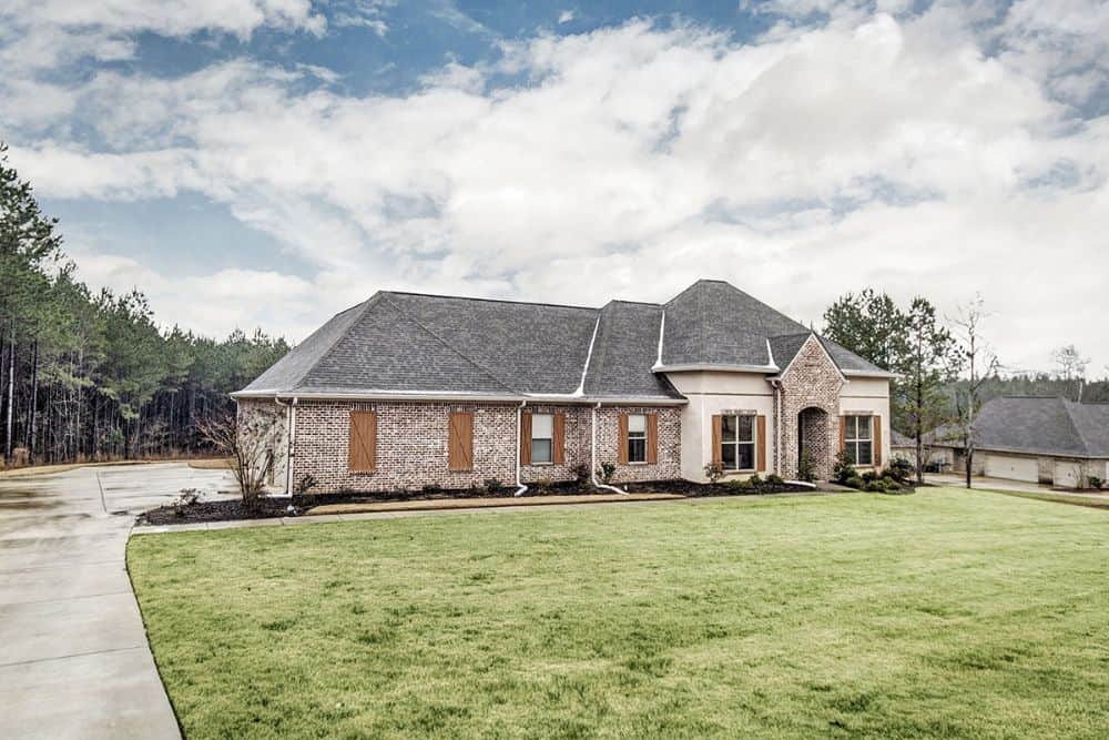 A farther view shows the concrete driveway and lush green lawn.