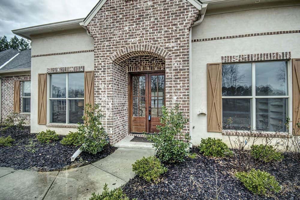 Home entry with a brick archway and a french front door.
