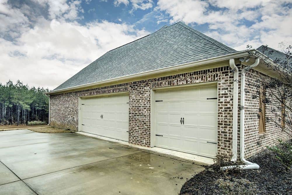 Side-entry garage enclosed in white oversized garage doors.