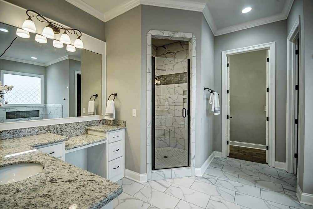 A walk-in shower enclosed in a glass hinged door completes the primary bathroom.
