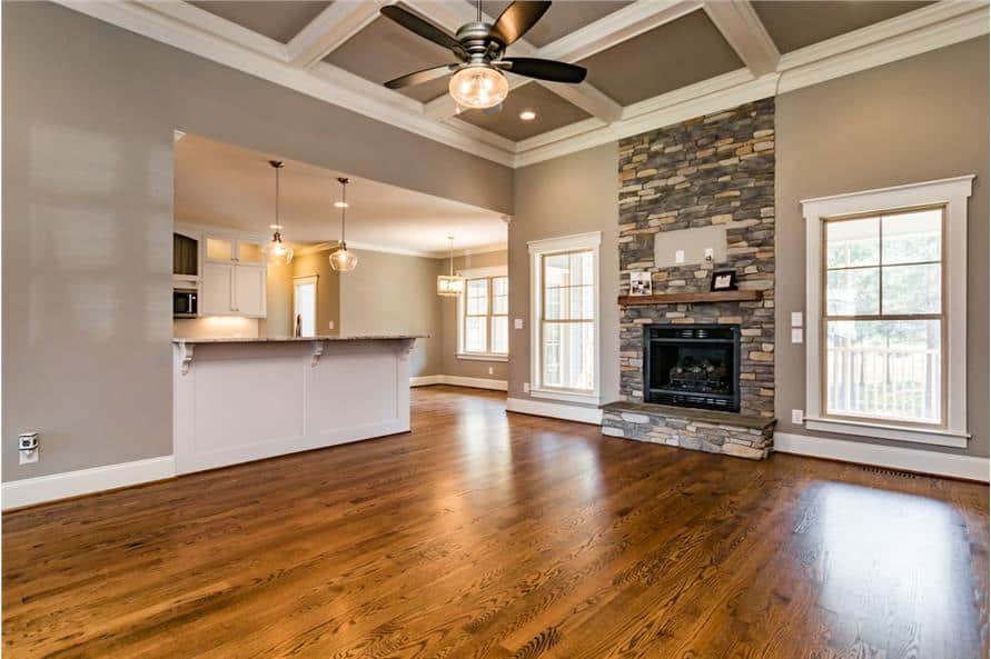 The living room features a stone fireplace and a coffered ceiling mounted with a fan.