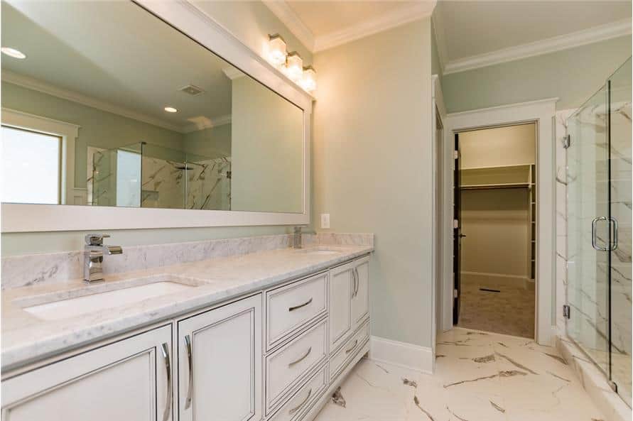 The primary bathroom is equipped with a walk-in shower and closet along with a dual sink vanity.