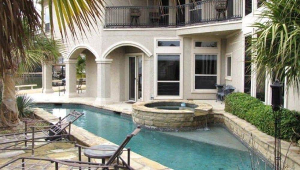Rear patio with a swimming pool and built-in spa.