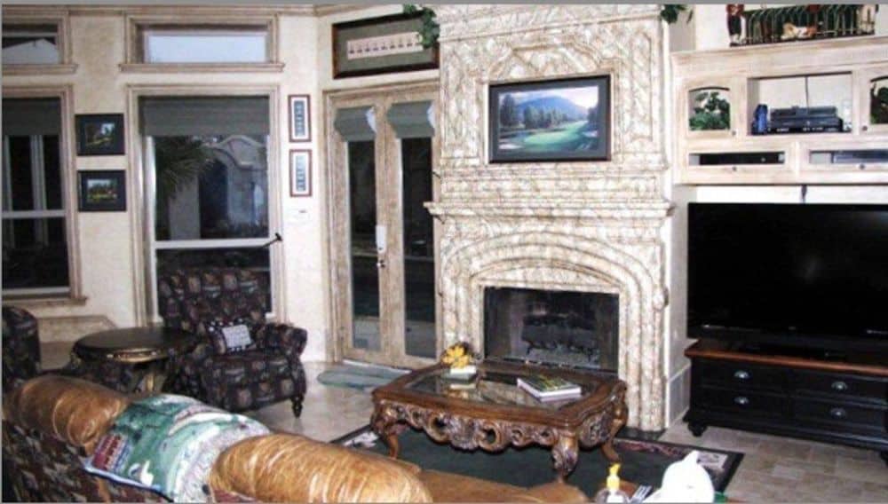 A closer look at the fireplace adorned with a landscape painting.