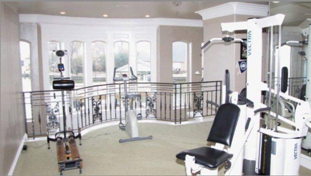 Second-floor balcony filled with gym equipment.