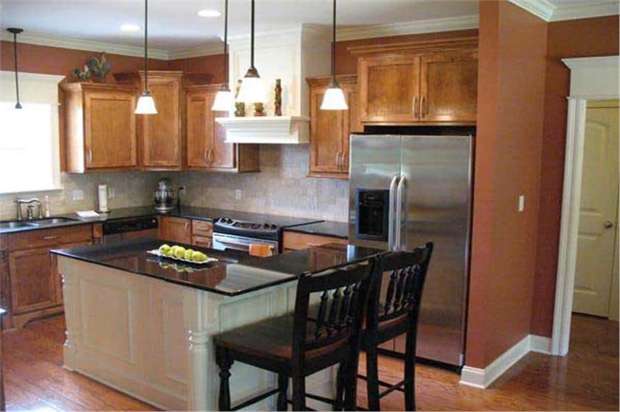 The kitchen is equipped with stainless steel appliances, wooden cabinetry, and an L-shaped island with an eating bar.