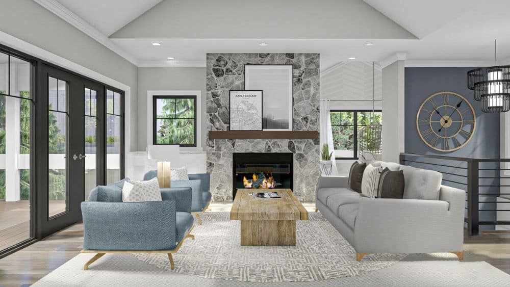 Living room with a stone fireplace, upholstered seats, and a wooden coffee table sitting on layered rugs.