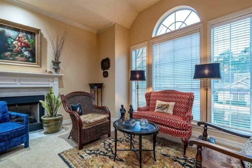 Living room with mismatched seats, a fireplace, and a Palladian window that invites natural light in.