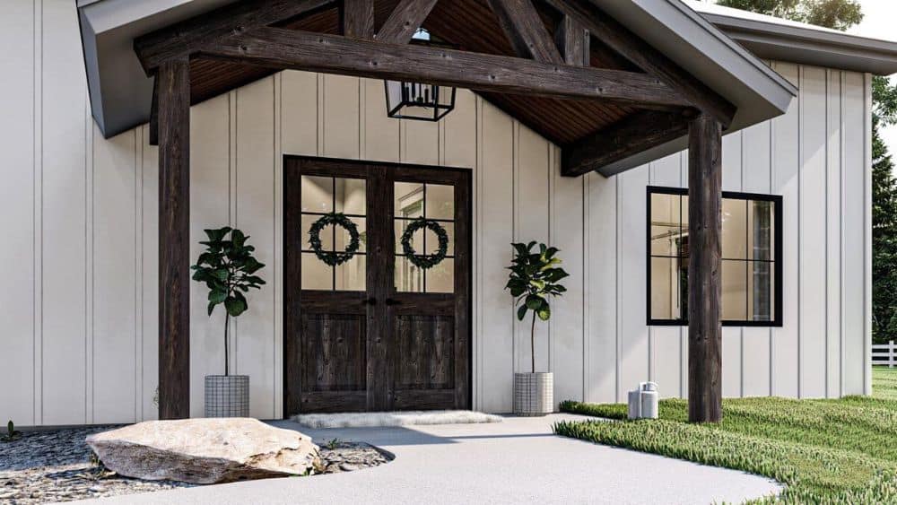 Home entry with a french front door and a covered patio framed with rustic trusses.