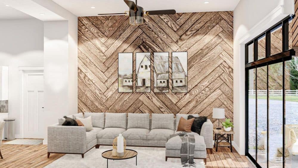 The great room includes a gray sectional, round coffee table, and a multi-panel artwork gracing the herringbone wood accent wall.