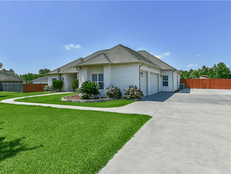 Side exterior view showing the three-car garage complemented with a spacious driveway.