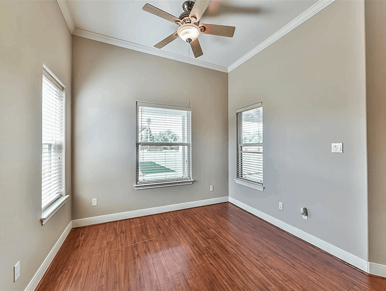 This spare space with hardwood flooring and a shed ceiling is dedicated to the guest bedroom.
