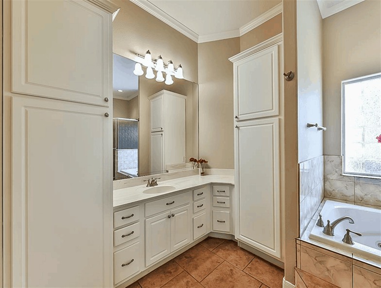 A frameless mirror and linen closet complement the sink vanity.