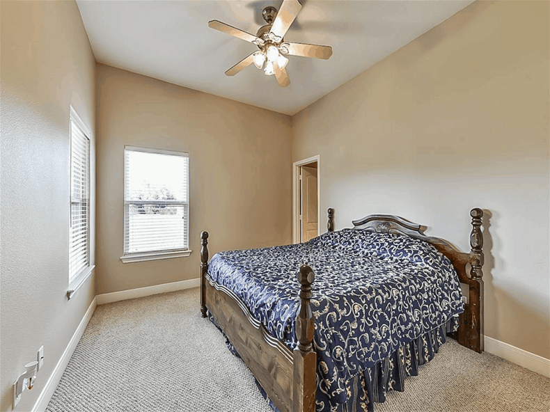 Another bedroom with carpet flooring, beige walls, and a shed ceiling mounted with a fan.