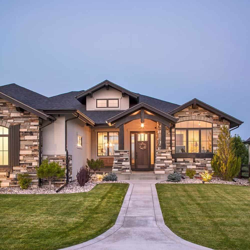 A closer look at the entry porch showing its tapered columns, wooden trims, and a gable roof.