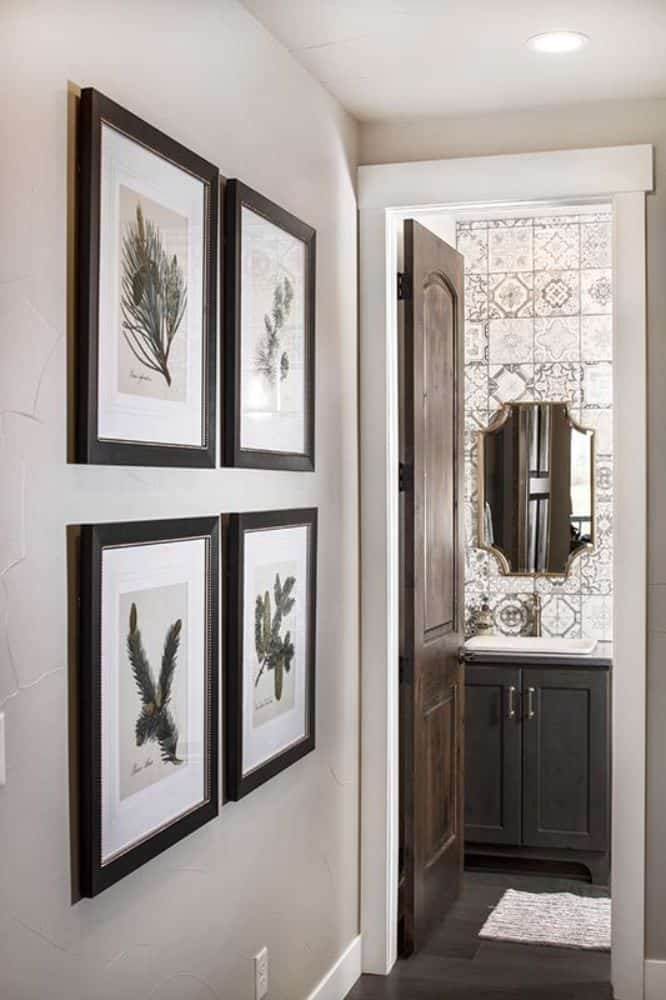 A gallery wall adorns the entrance of this bathroom.
