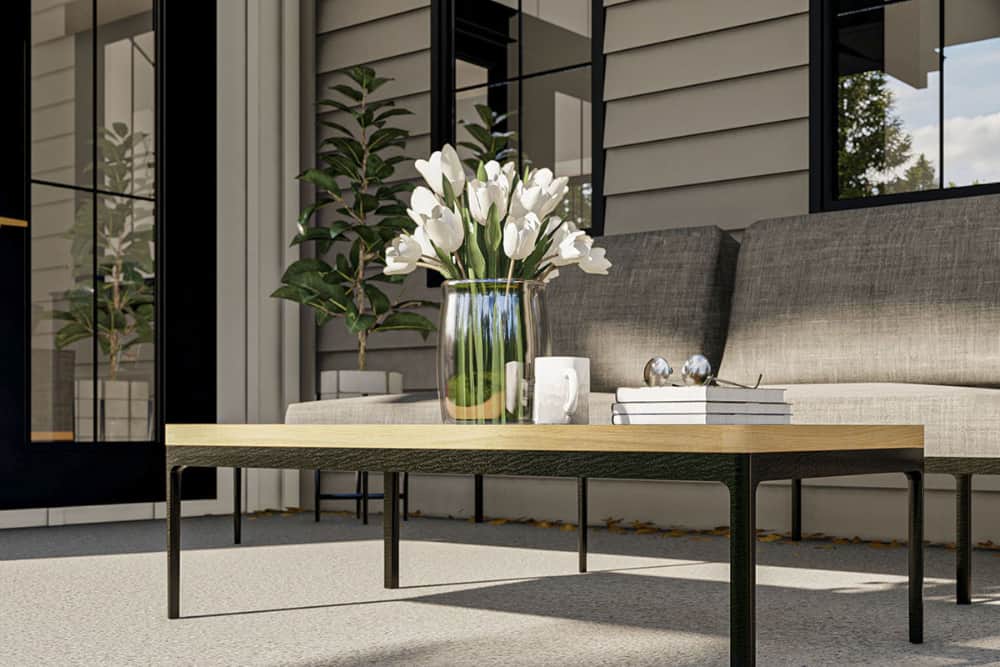 Covered porch with a gray sofa and a wooden coffee table over concrete flooring.