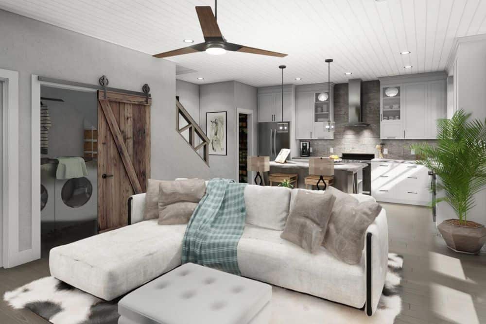 Family room with a sleek ceiling fan and an L-shaped sofa paired with a tufted ottoman.
