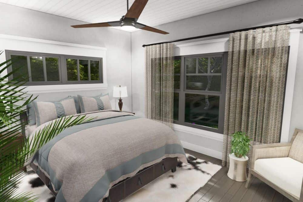 Primary bedroom with a comfy bed, a beige armchair, and framed windows dressed in sheer curtains.
