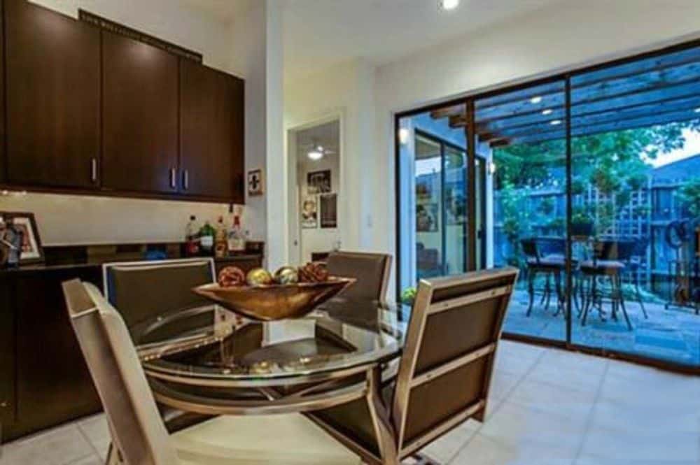 Breakfast nook with built-in cabinets and a round dining set over tiled flooring.