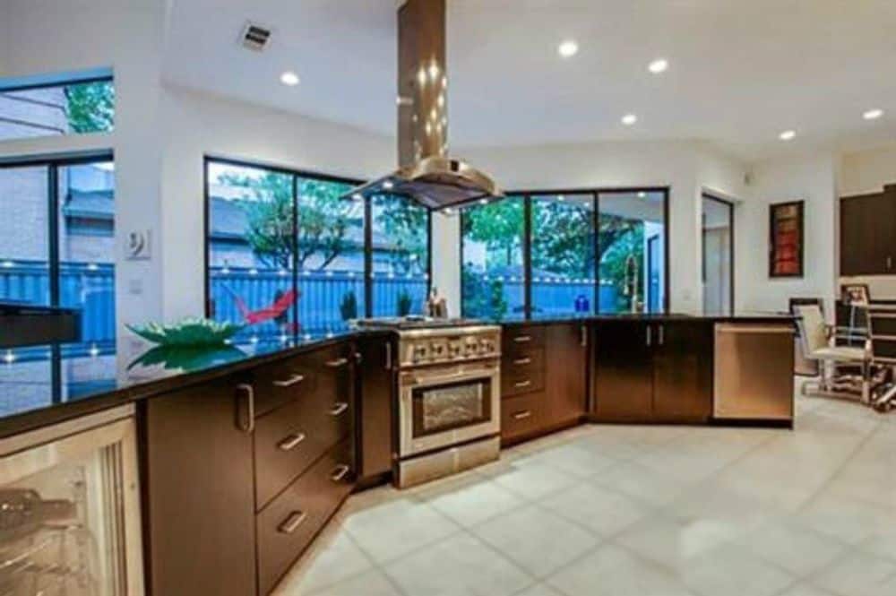 The kitchen offers dark wood cabinets and a stainless steel range topped with a matching vent hood.