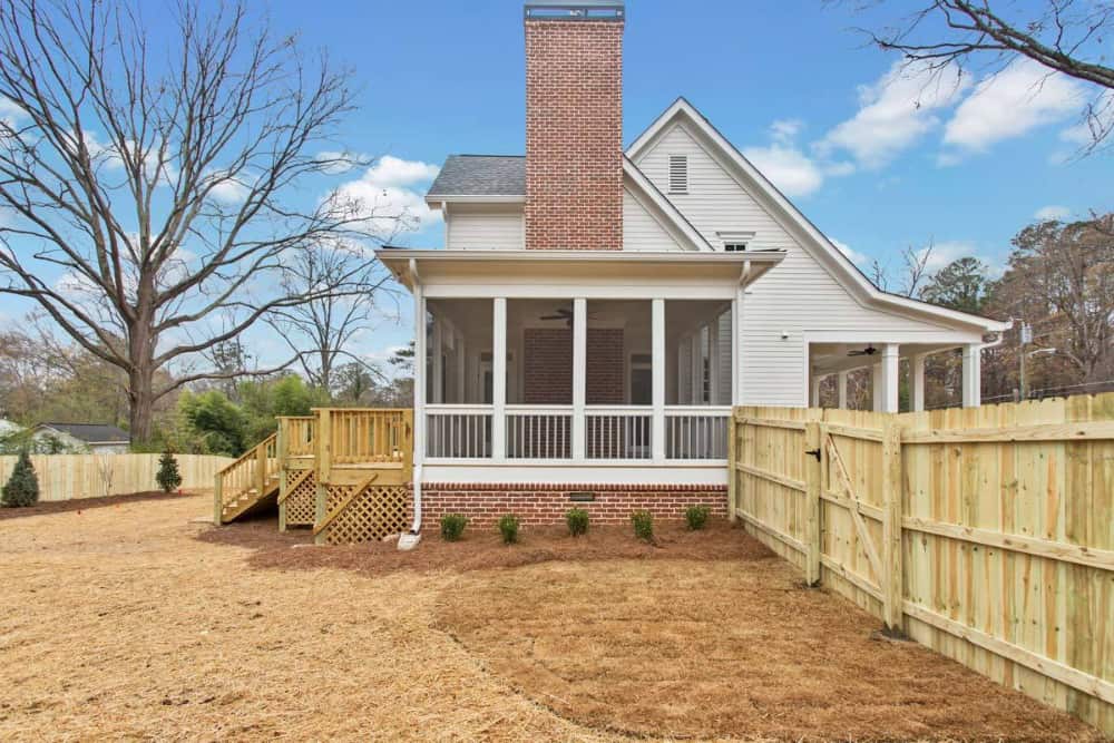 Left exterior view with screened porch and brick base matching with the chimney.