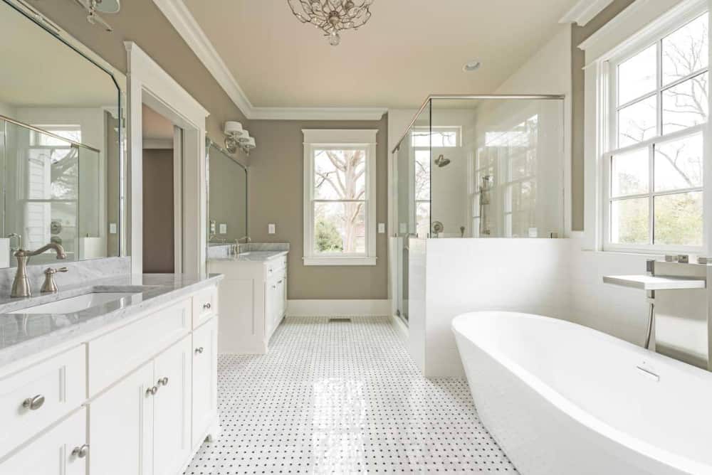 The primary bathroom is equipped with his and her sink vanities, a walk-in shower, and a freestanding tub.