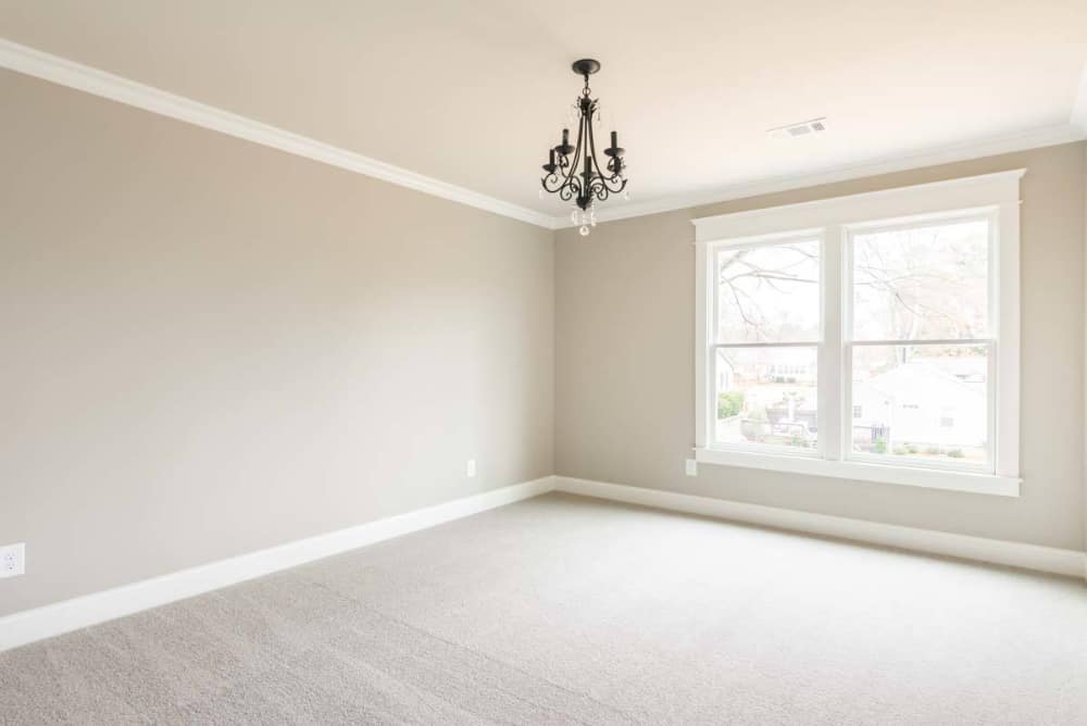 This bedroom offers carpet flooring and a large window allowing ample natural light in.