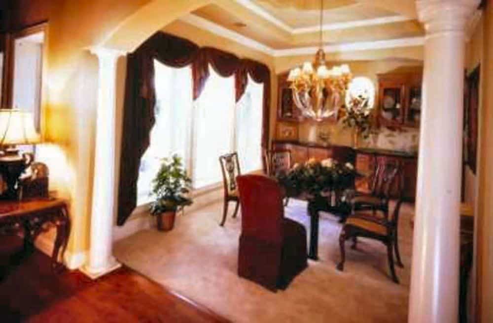 Formal dining room with a built-in buffet cabinet and a classy dining set for six topped with a step ceiling.