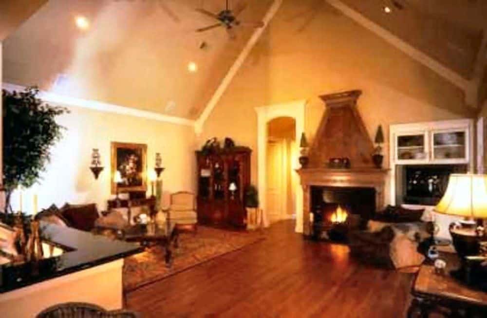 The family room features a cozy fireplace and a high cathedral ceiling fitted with recessed lights and fans.