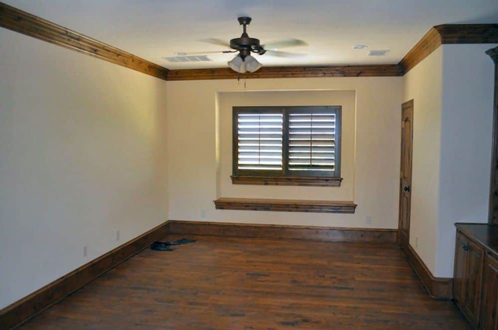 The game room has hardwood flooring, beige walls, and a louvered window fitted against the inset wall.