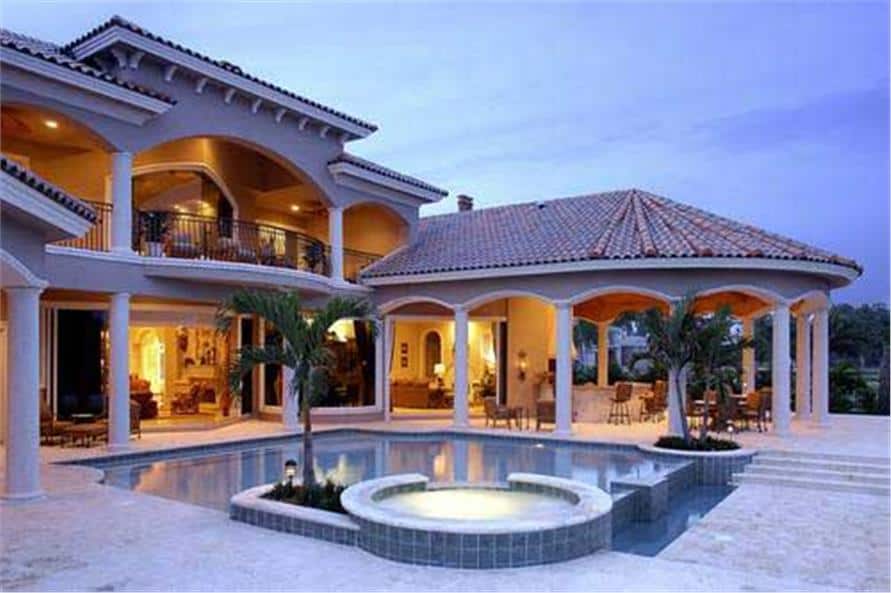 View of the house from the backyard showing the covered lanai and swimming pool with a built-in spa.